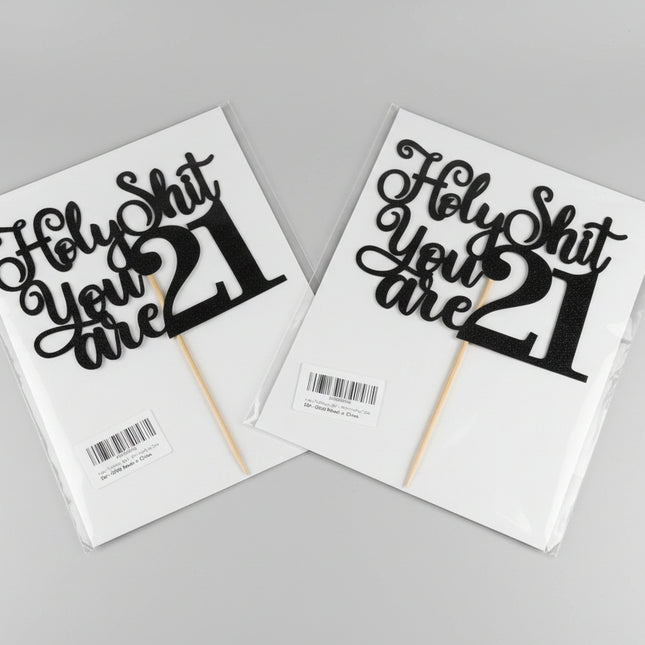 Two 'Holy Shit You Are 21' cake toppers on packaging with a neutral background.